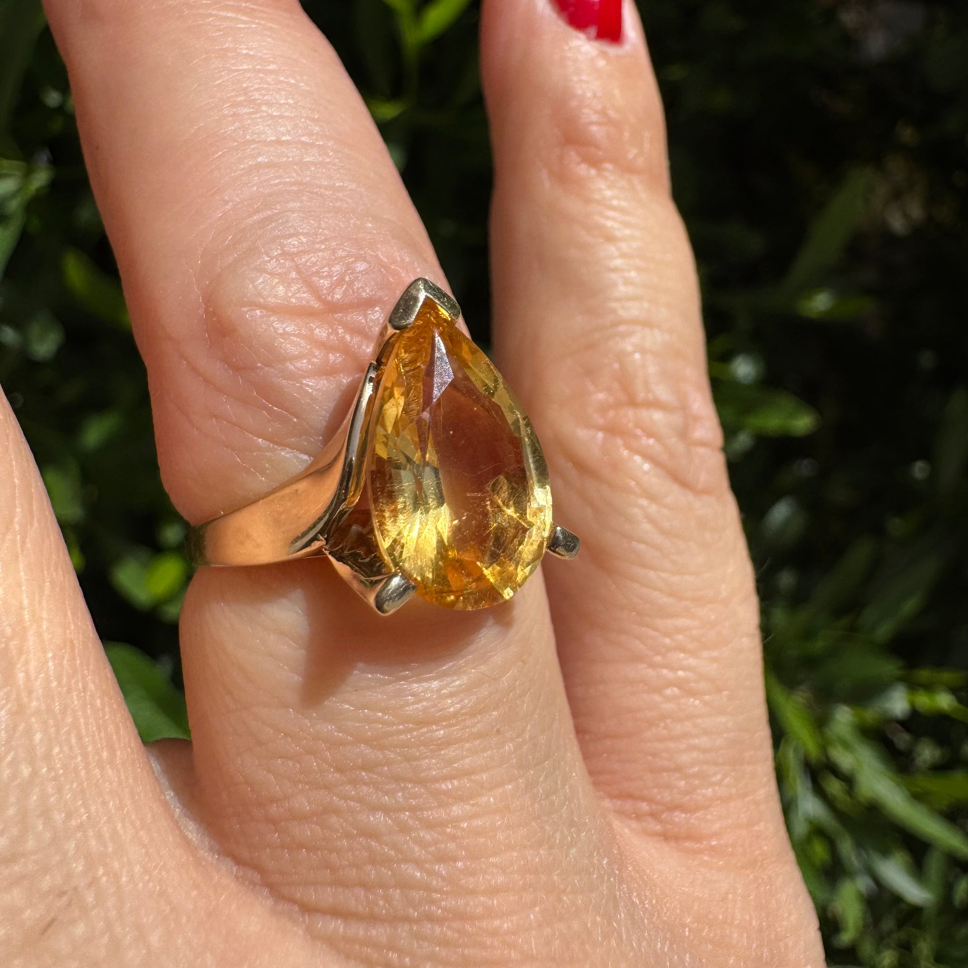 טבעת זהב צהוב 14 קראט משובצת באבן סיטרין גדולה בחיתוך טיפה, עם זהב שמחבק אותה בצורה פתוחה ומודרנית.
