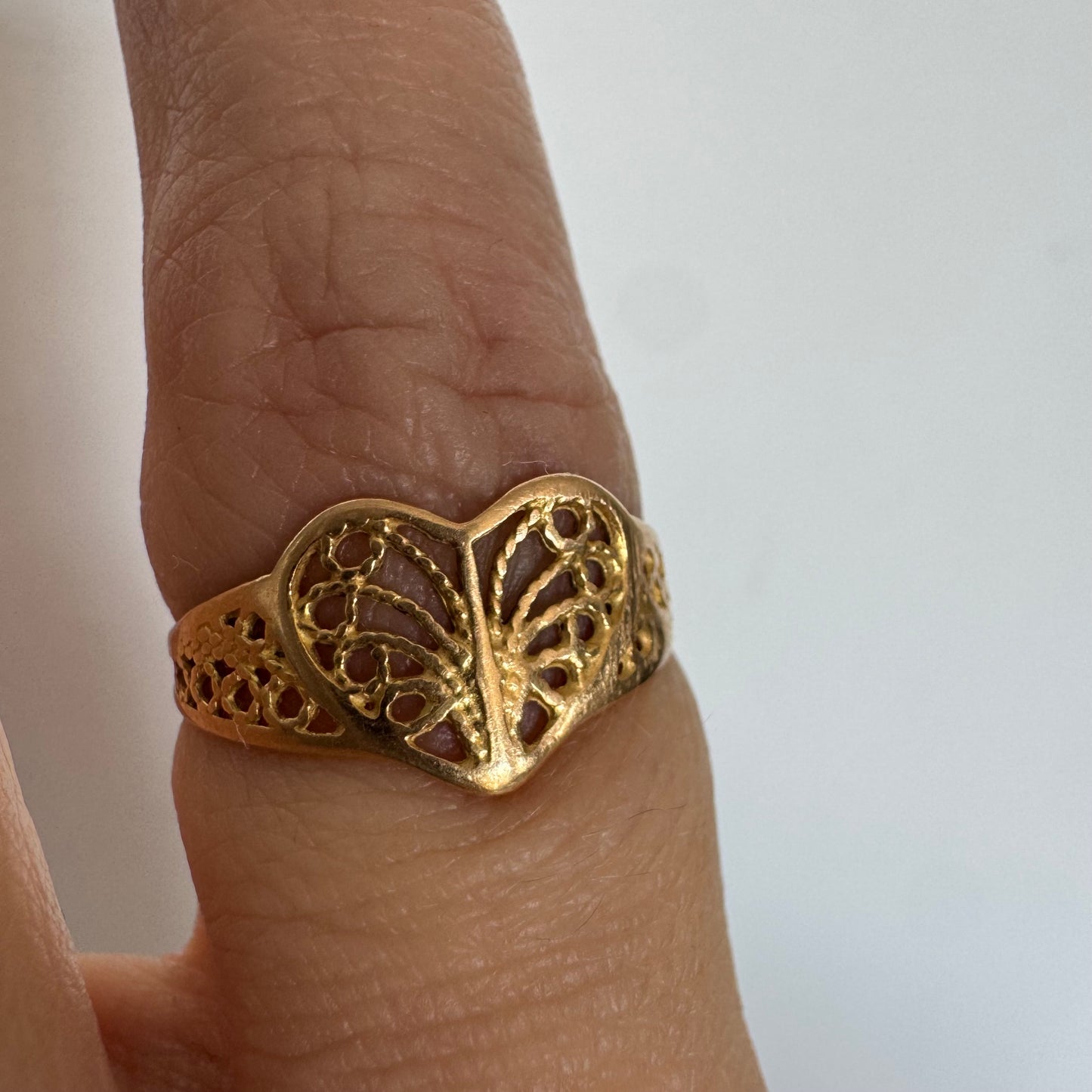 טבעת זהב 21 קראט בעיצוב לב עדין עם עבודת פיליגרן פתוחה.