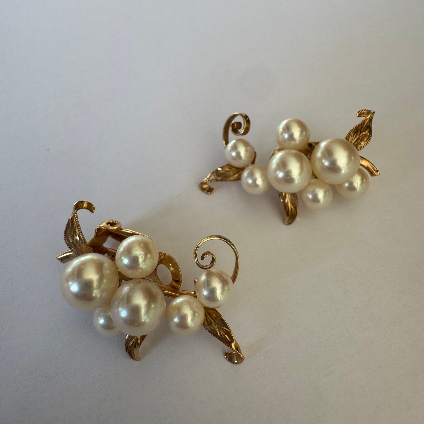 עגילי קליפס זהב 14 קראט, משובצים אשכול פנינים בגווני לבן-קרם.