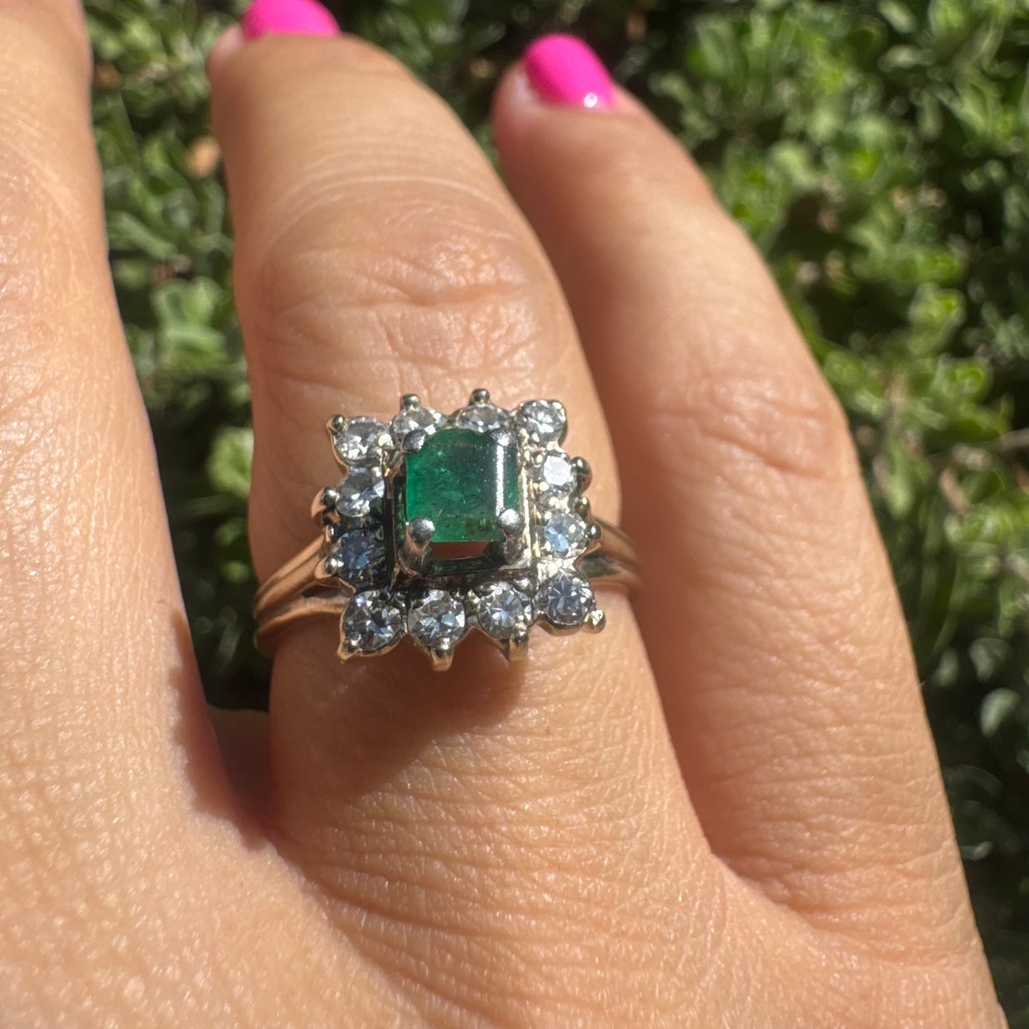 18K gold ring set with a vibrant square-cut Emerald surrounded by a sparkling halo of Diamonds.