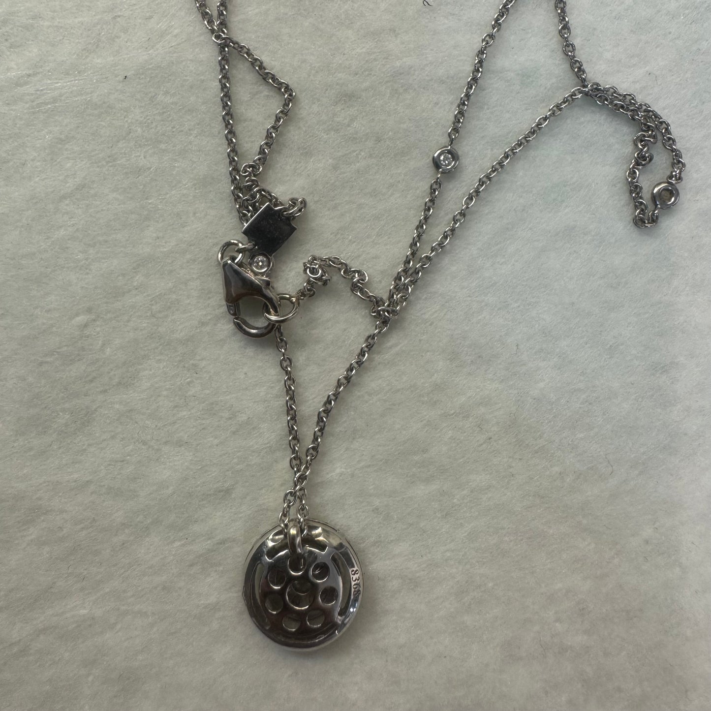 14K gold necklace featuring a round pendant set with a cluster of sparkling Diamonds