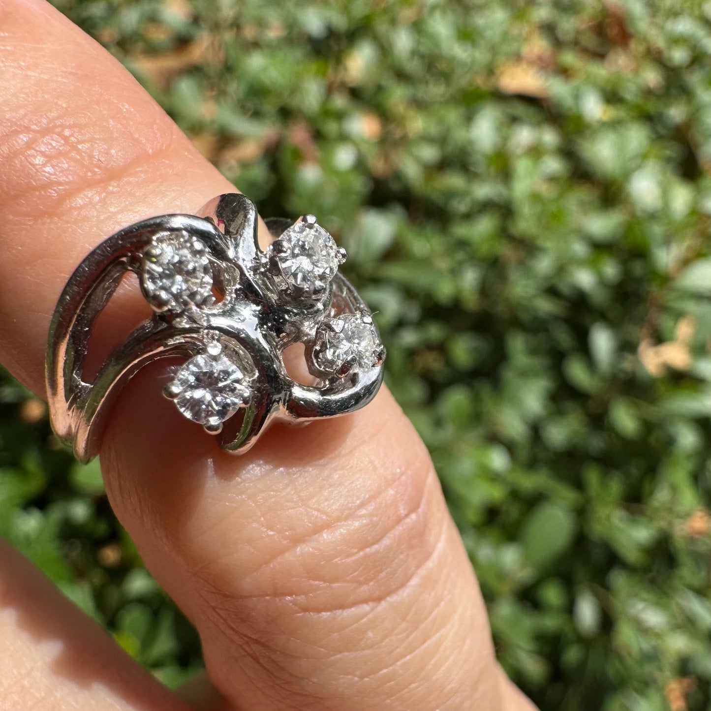 14K gold ring set with four brilliant-cut Diamonds, arranged in an elegant flowing design