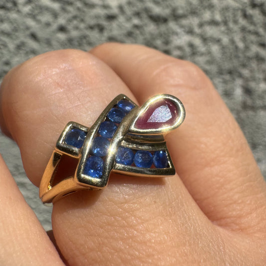 10K gold ring set with a pear-shaped Ruby and deep blue Sapphires in a geometric design.