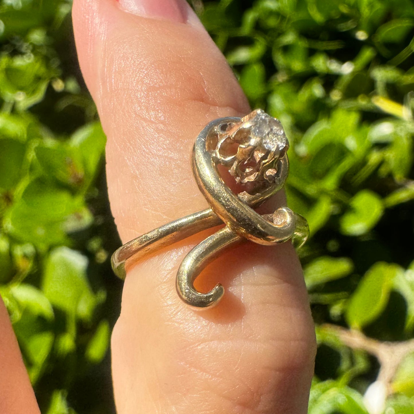 14K gold ring set with a brilliant-cut Diamond, embraced by a flowing, sculptural gold design