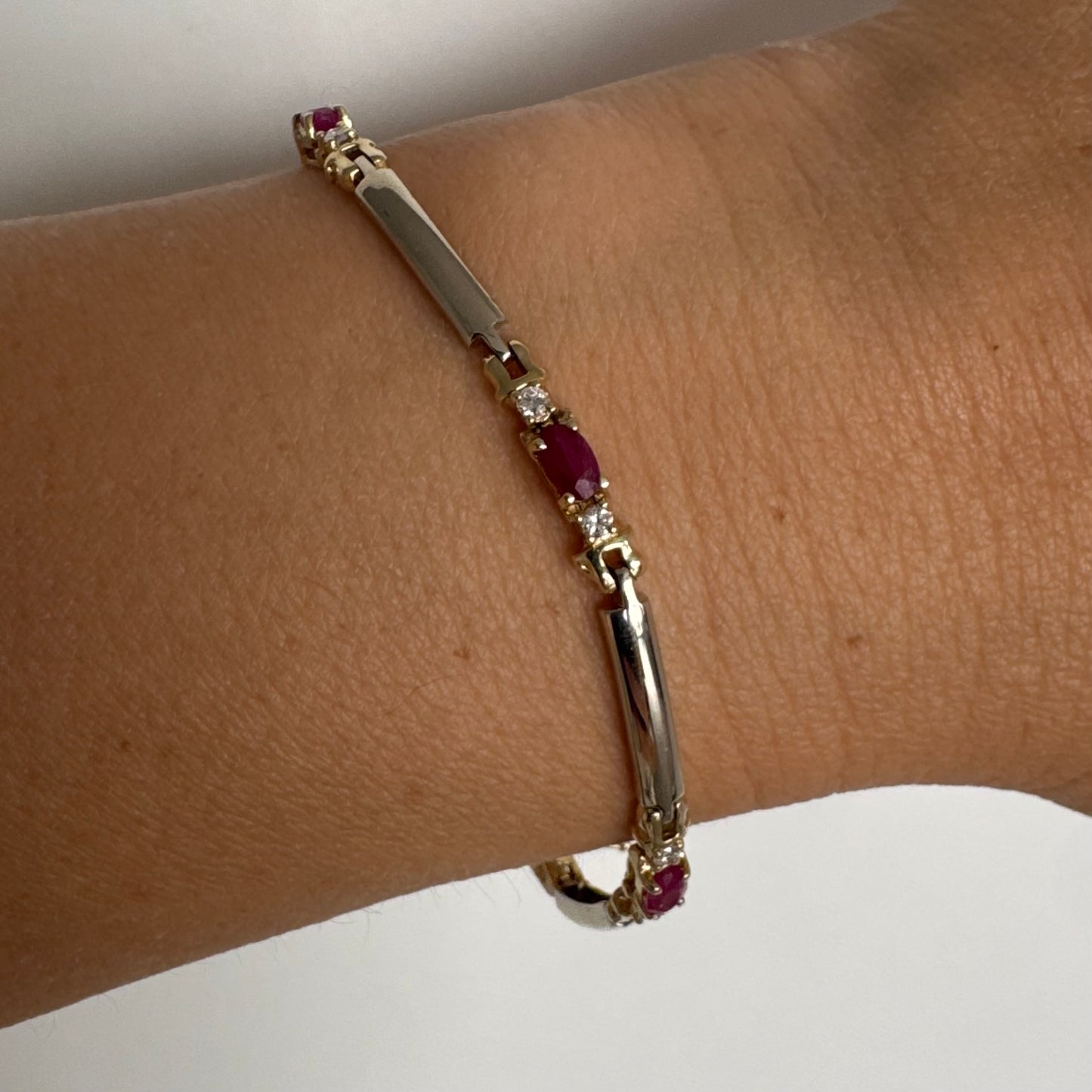 צמיד זהב צהוב 14 קראט משובץ אבני רובי אדומות בחיתוך אובלי, עם יהלומים המשובצים ביניהן להוספת ברק עדין.