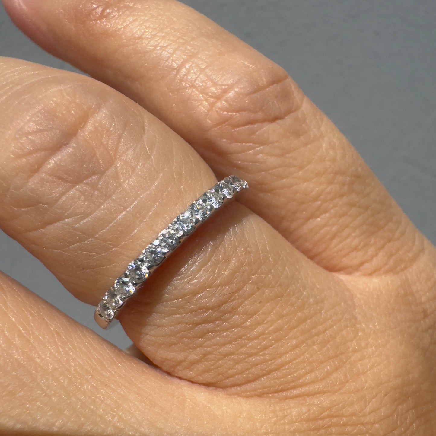 טבעת זהב לבן 14 קראט, חצי איטרניטי, משובצת בשורת יהלומים עגולים ונוצצים .