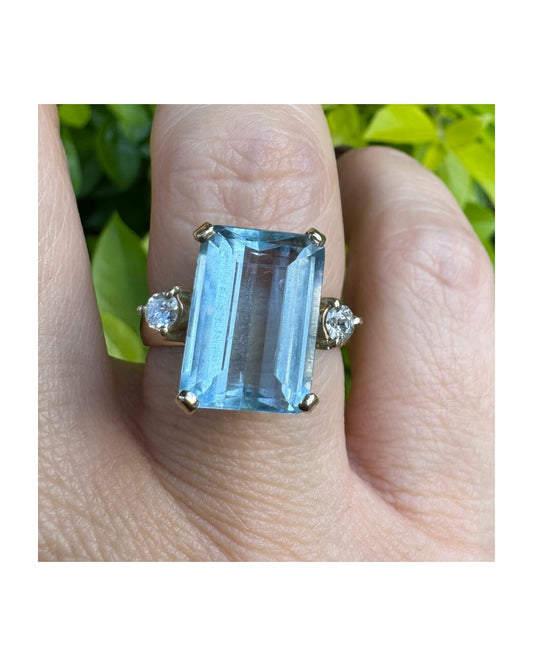 טבעת זהב 18 קראט משובצת אבן אקוומרין בחיתוך מלבני (Emerald Cut), בעלת גוון כחול צלול ומרשים.