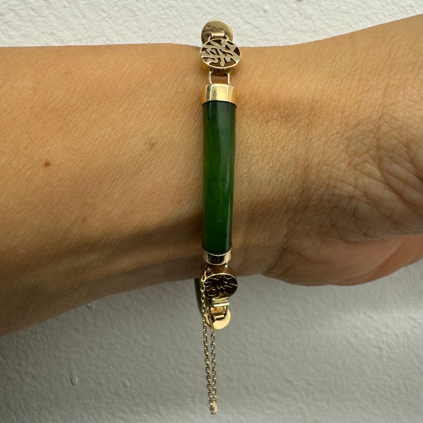 צמיד זהב צהוב 18 קראט משובץ אבני ג’ייד ירוקות עם עיטורי זהב בעיצוב אסייתי מסורתי – שילוב הרמוני של אלגנטיות, משמעות רוחנית וסטייל ייחודי