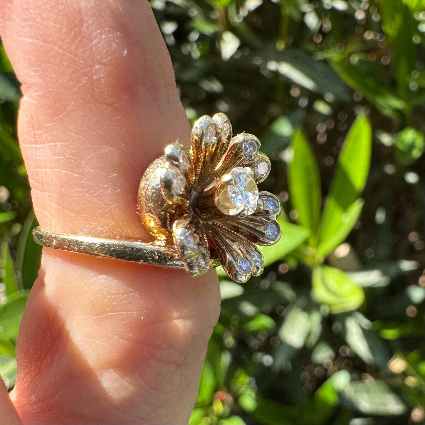 14K gold ring in a floral design, set with sparkling Diamonds at the center and around the petals.