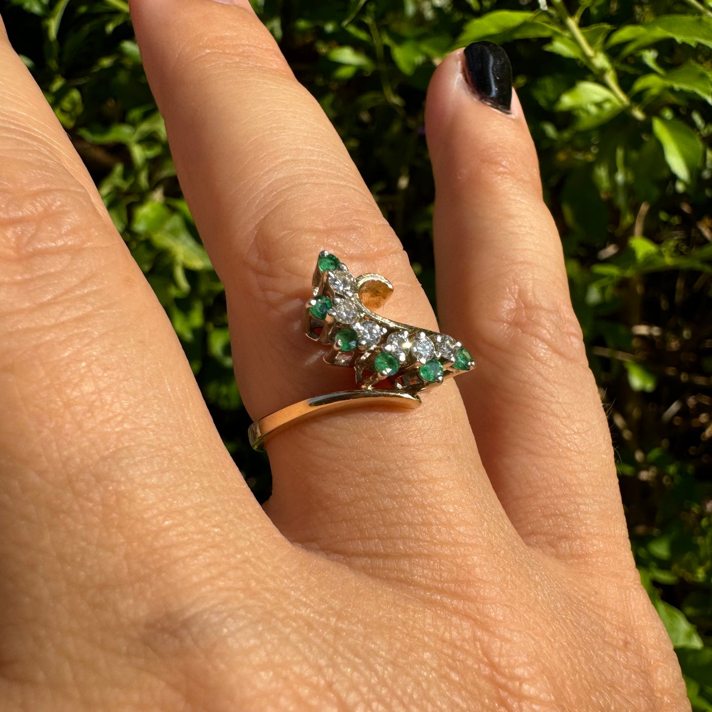 14K gold open ring featuring a delicate swirl set with Emeralds and brilliant-cut Diamonds