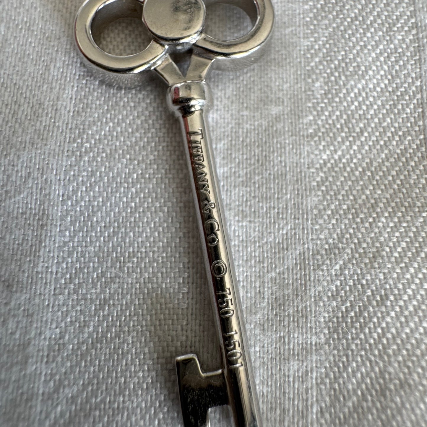 תליון מפתח אייקוני של Tiffany & Co. זהב לבן 18 קראט משובץ יהלומים עדינים.