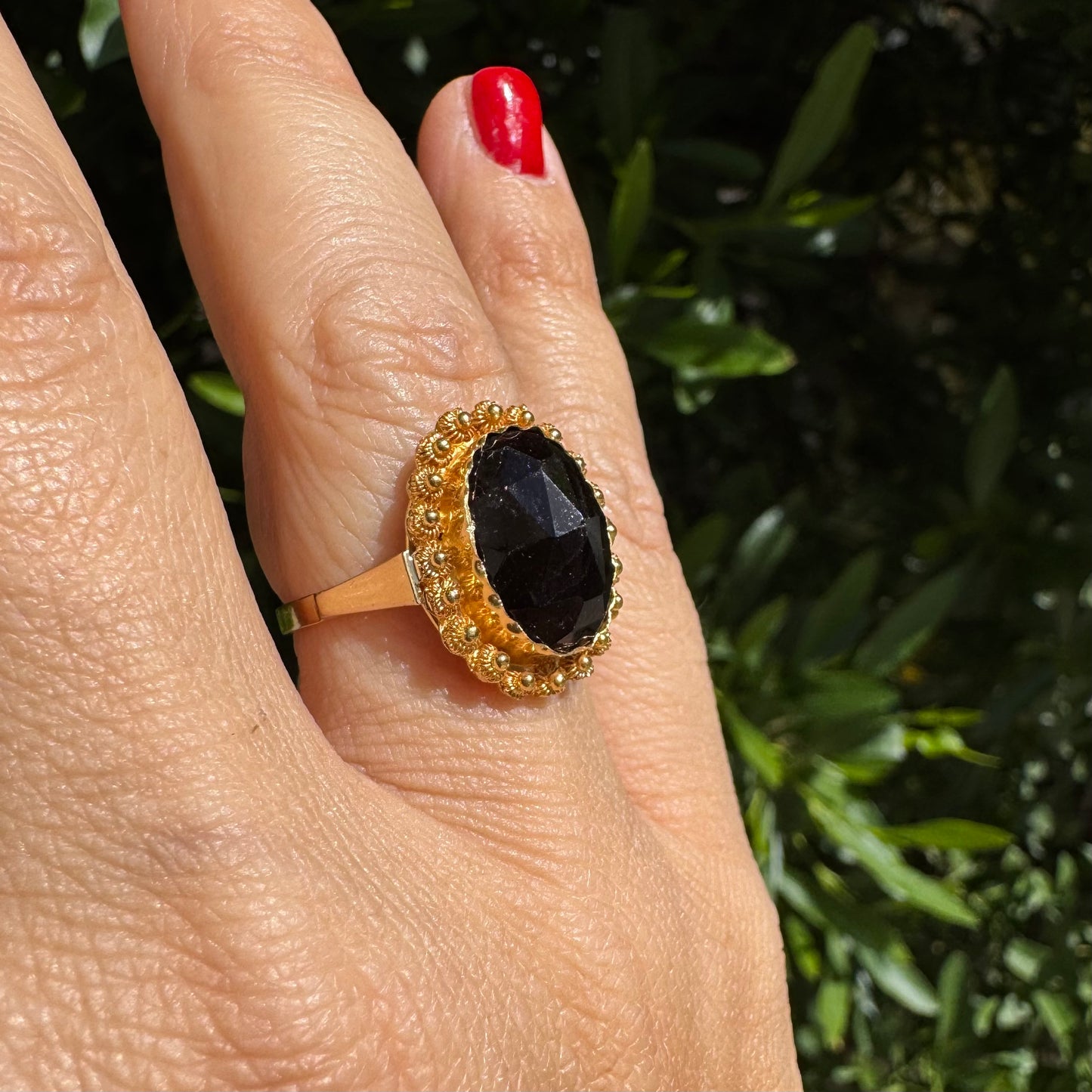 14K gold ring set with a large Garnet surrounded by delicate gold details