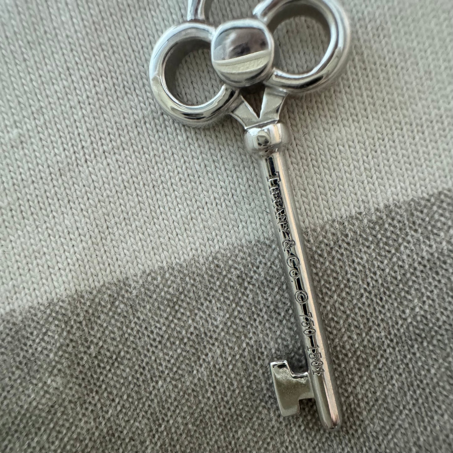 תליון מפתח אייקוני של Tiffany & Co. זהב לבן 18 קראט משובץ יהלומים עדינים.