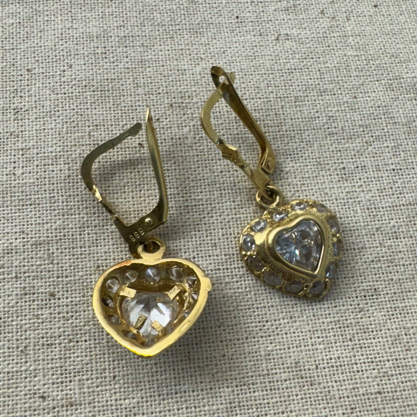 14K gold drop earrings set with a heart-cut central stone & surrounded by a halo of delicate gems.