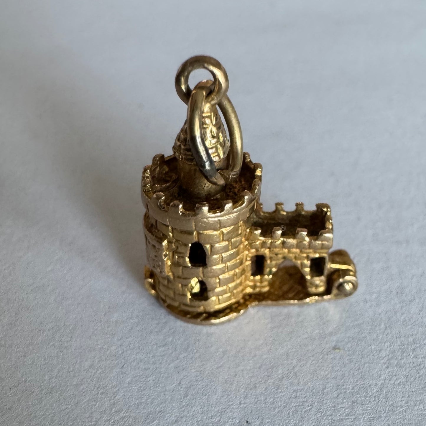 תליון זהב 9 קראט נדיר וייחודי, המהווה העתק פיסולי מפורט של ה-Bloody Tower (המגדל העקוב מדם) המפורסם ממצודת לונדון. התליון מעוצב בתלת-ממד (3D) עם טקסטורת לבנים מפורטת, צריחים, וחריטה של שם המגדל בגבו.