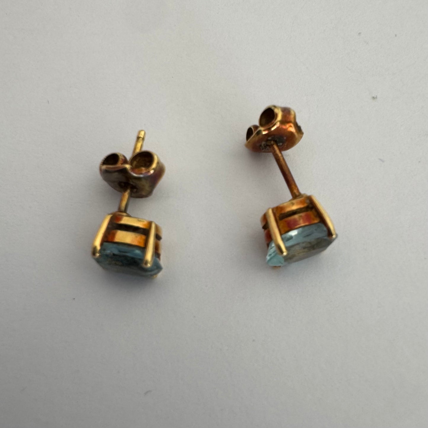 18K gold stud earrings set with oval-cut Aquamarines.