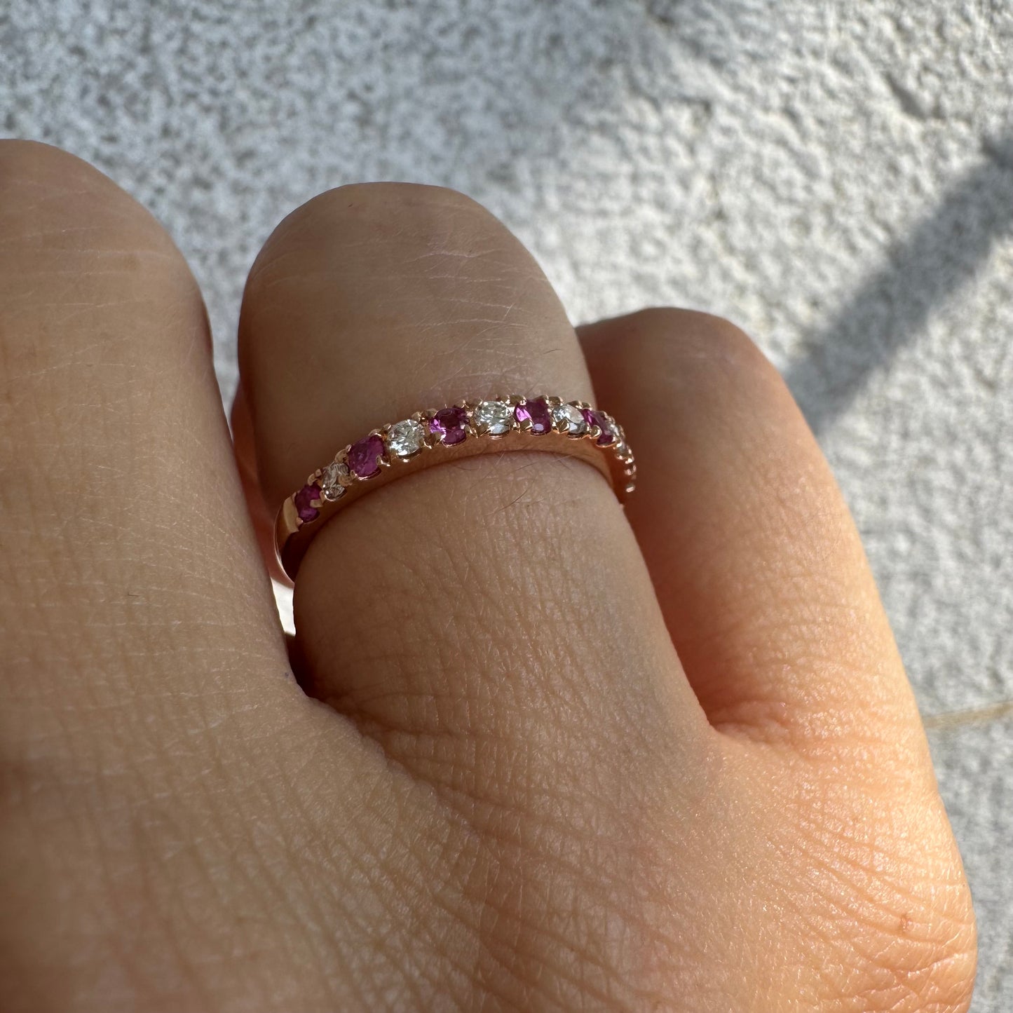 טבעת חצי איטרניטי מזהב אדום 14 קראט, משובצת ברצף של אבני רובי ויהלומים .