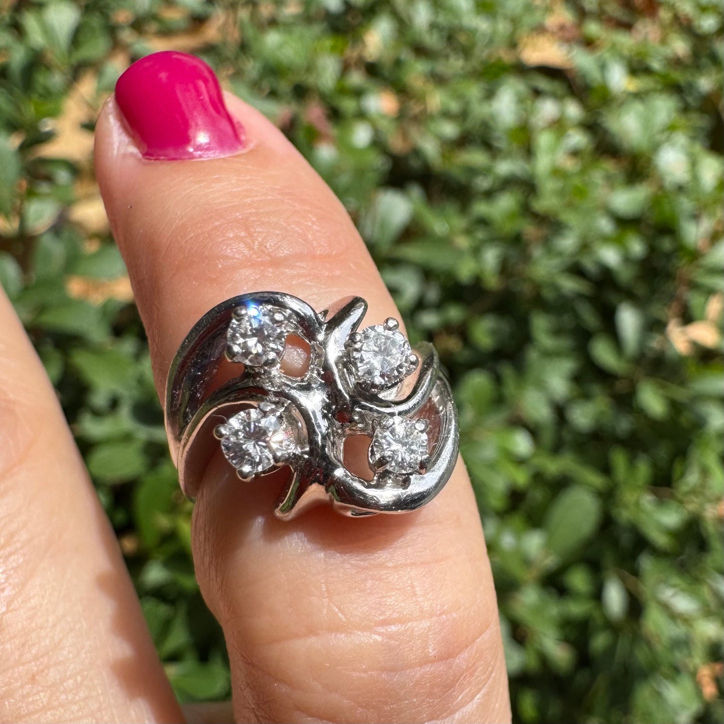 14K gold ring set with four brilliant-cut Diamonds, arranged in an elegant flowing design