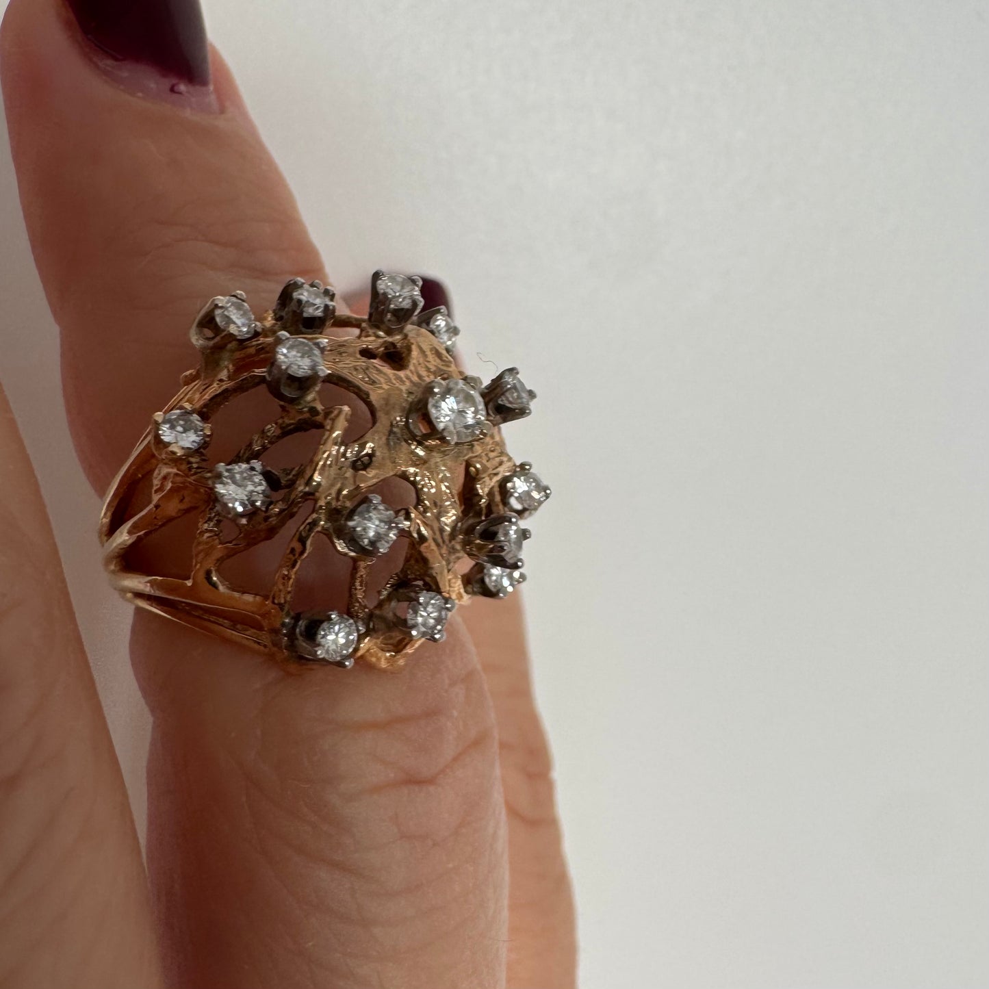 טבעת זהב 10 קראט בעיצוב פיסולי פתוח, משובצת יהלומים במבנה עגול דינמי.