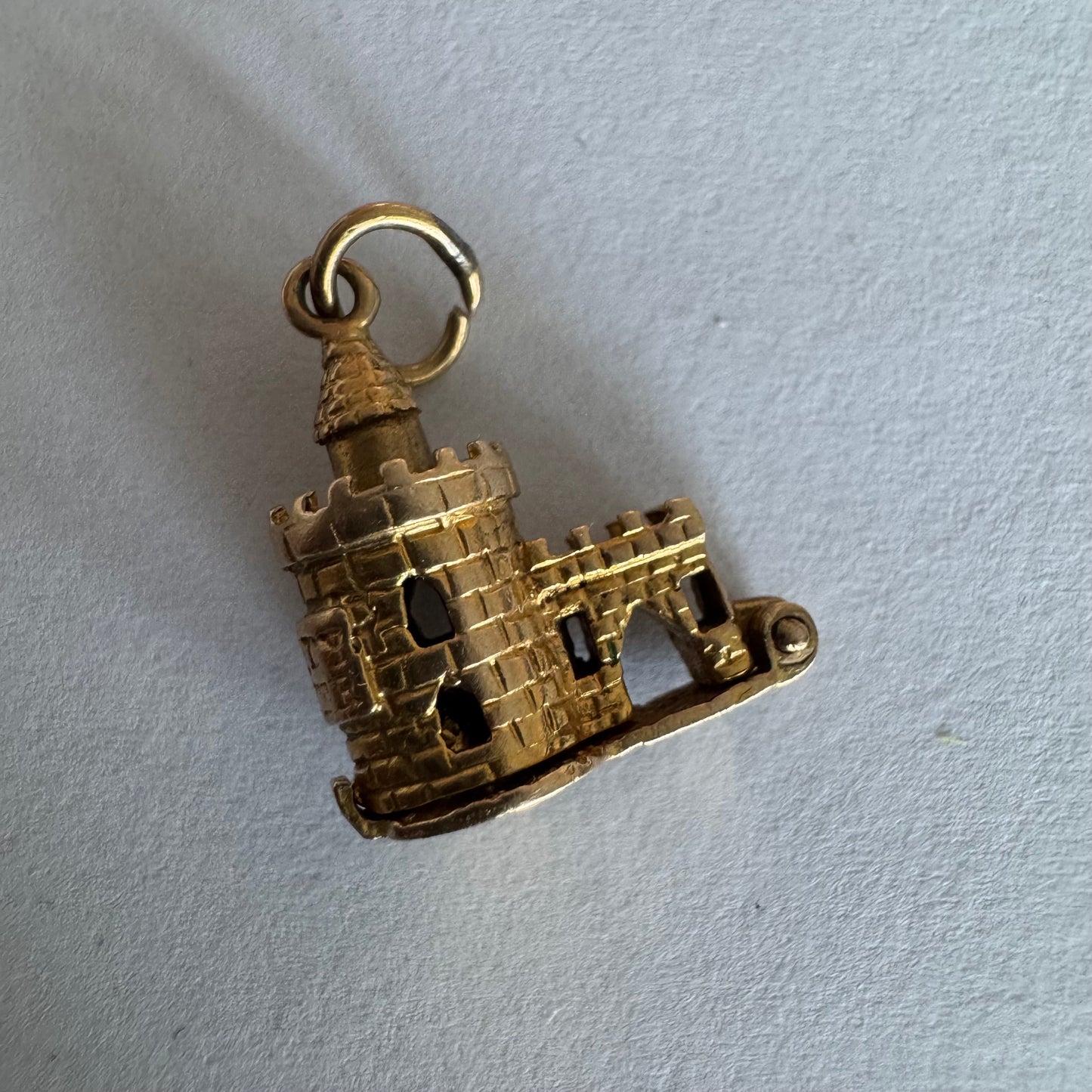 תליון זהב 9 קראט נדיר וייחודי, המהווה העתק פיסולי מפורט של ה-Bloody Tower (המגדל העקוב מדם) המפורסם ממצודת לונדון. התליון מעוצב בתלת-ממד (3D) עם טקסטורת לבנים מפורטת, צריחים, וחריטה של שם המגדל בגבו.