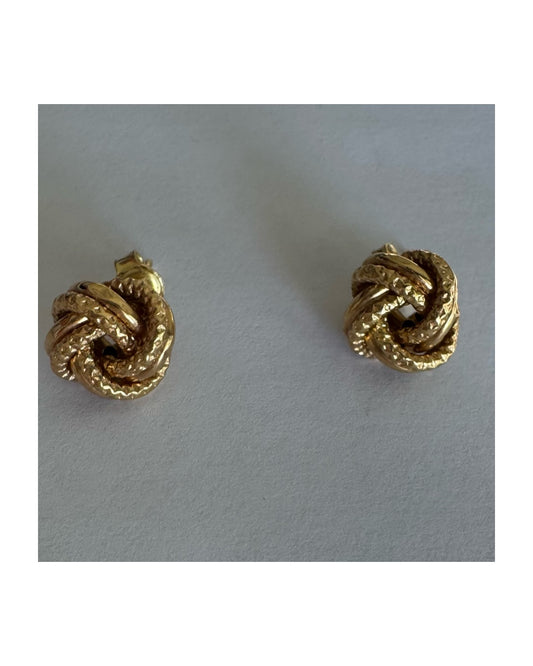 עגילי זהב צהוב 18 קראט בעיצוב קשר פיסולי, עם טקסטורה עשירה המדגישה את עומק וצורת הזהב.