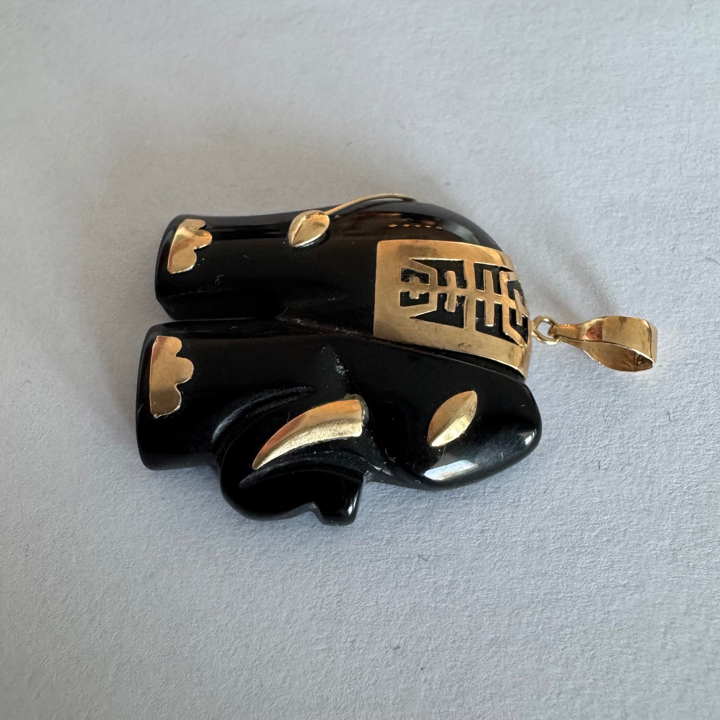 תליון זהב 9 קראט בעיצוב ייחודי ומלא נוכחות של פיל אפריקאי, המשלב גוף שחור מלוטש עם עיטורי זהב עדינים.