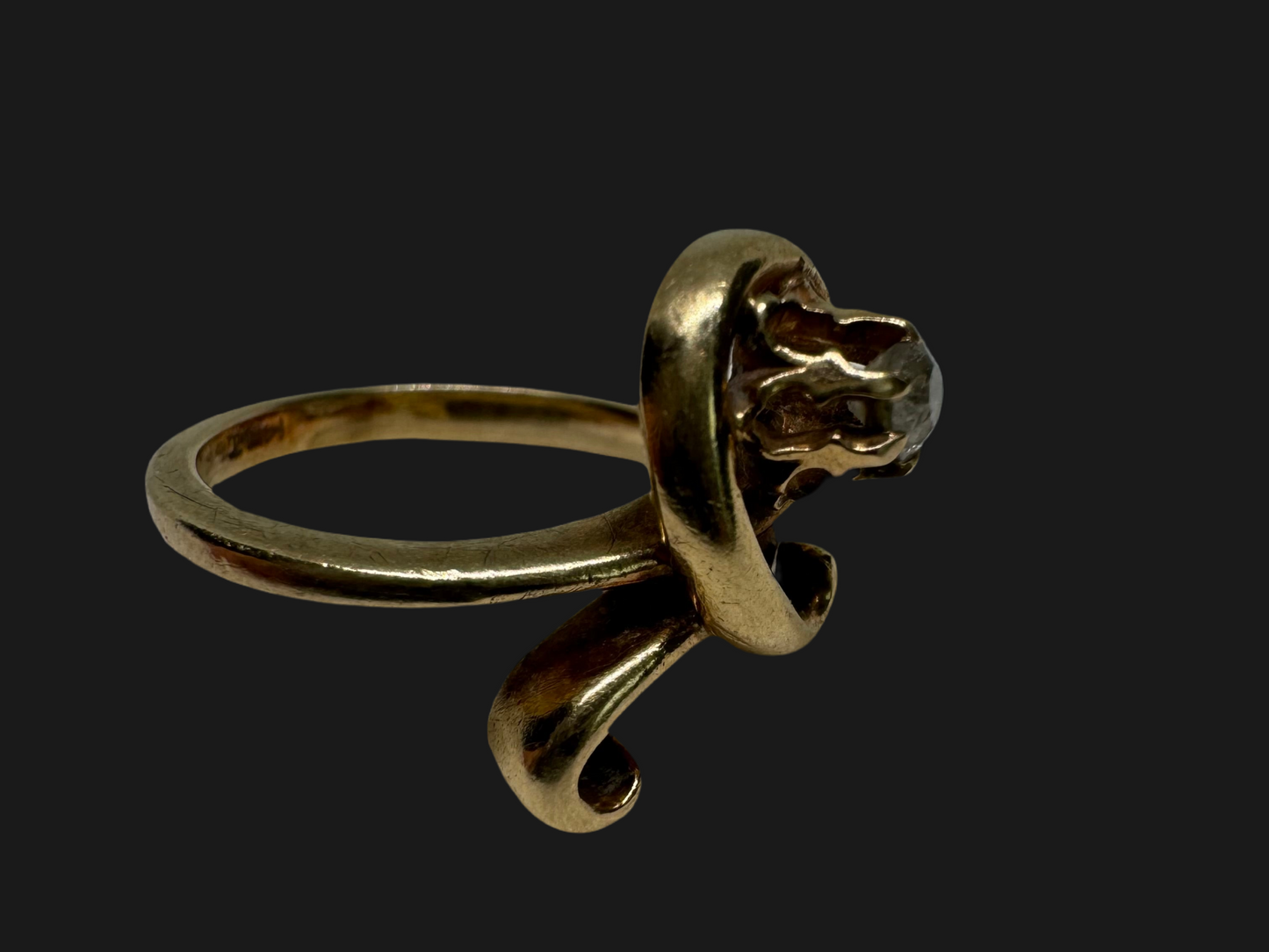 14K gold ring set with a brilliant-cut Diamond, embraced by a flowing, sculptural gold design