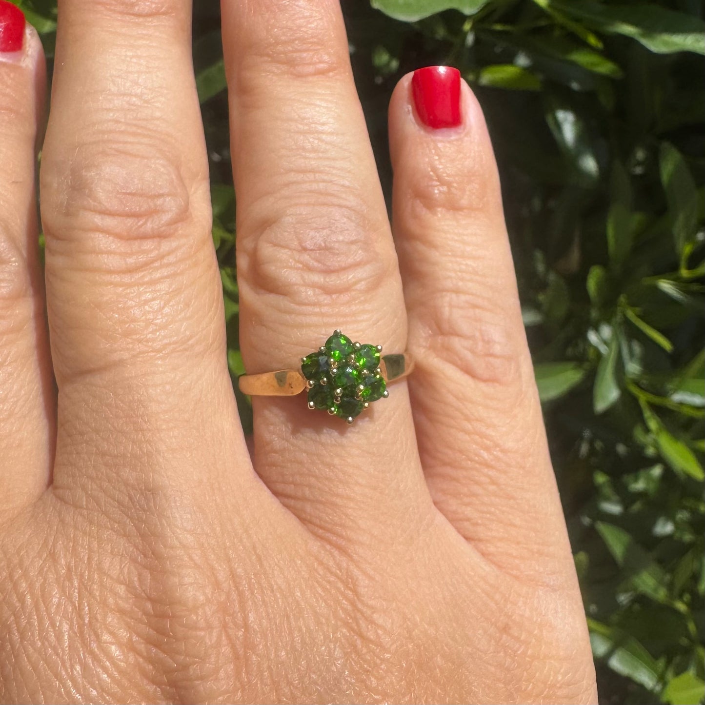 10K gold ring set with vivid green gemstones in a delicate floral cluster