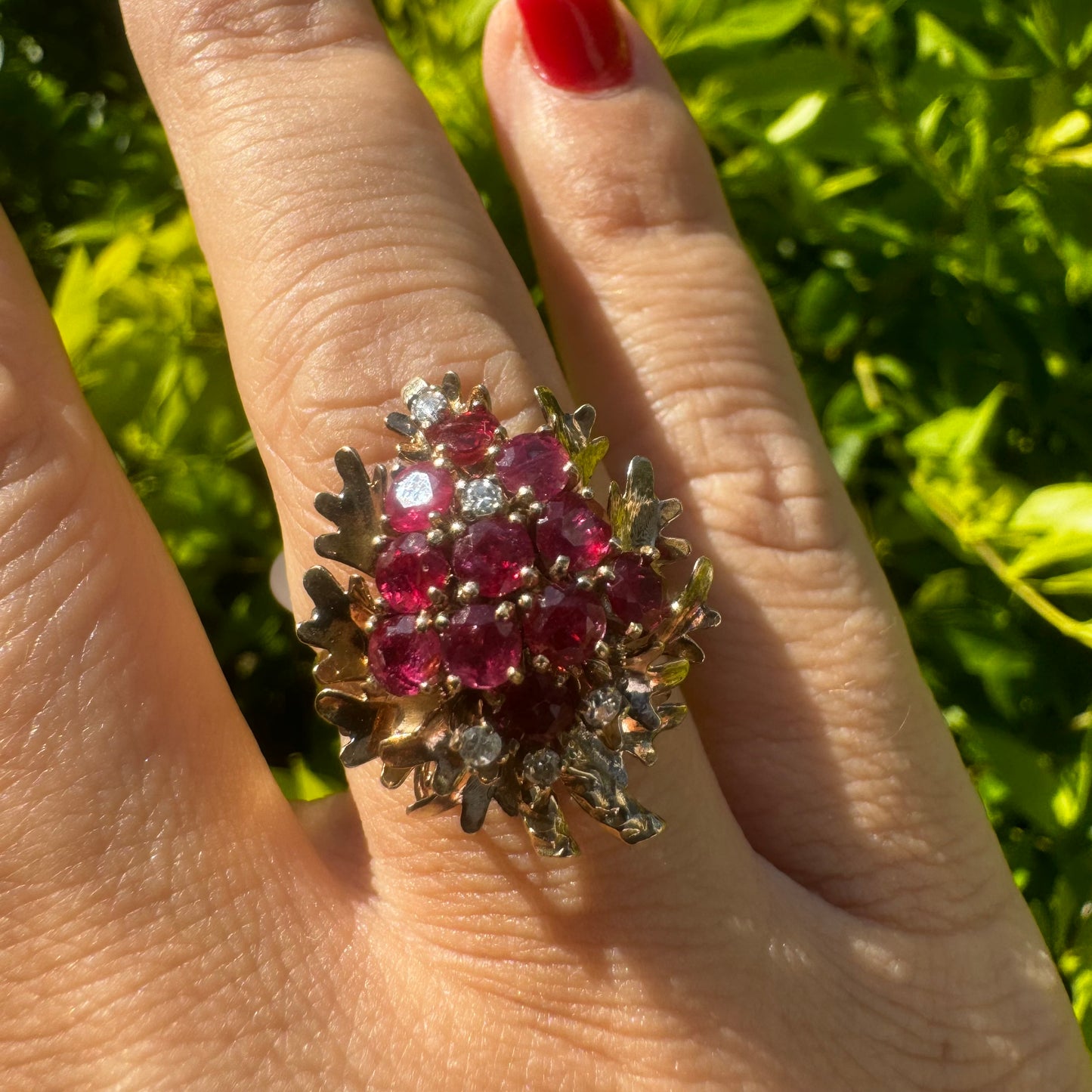 14K gold ring set with a vibrant cluster of deep red rubies and sparkling diamonds.