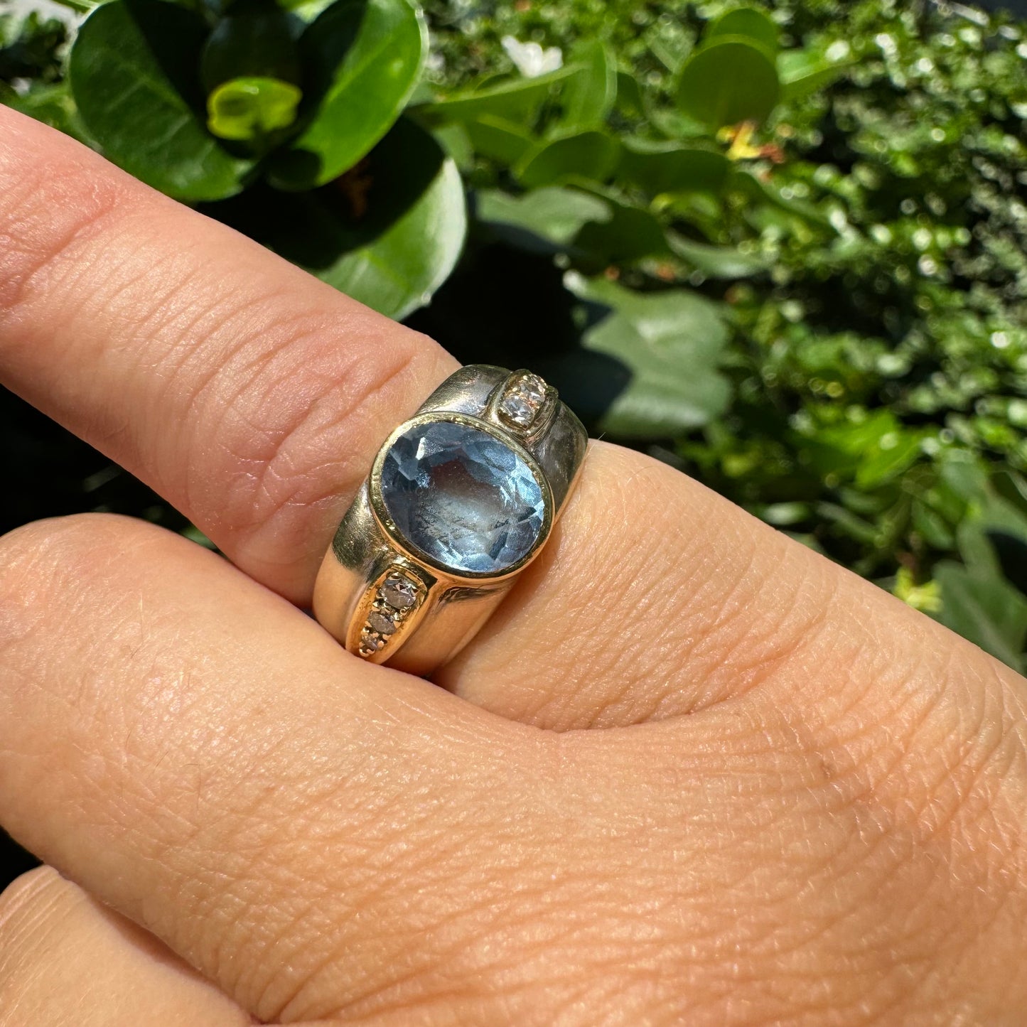 14K gold ring set with a luminous Blue Topaz at its center, accented by delicate side Diamonds