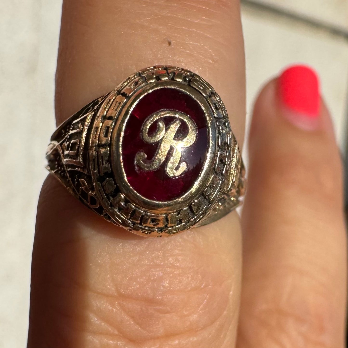 טבעת מחזור (Class Ring) מזהב 10 קראט, בעלת עיצוב אמריקאי קלאסי ובמרכזה אבן אדומה עם האות R עם חריטות וסמלים המעניקים לה אופי ייחודי ונוסטלגי.
