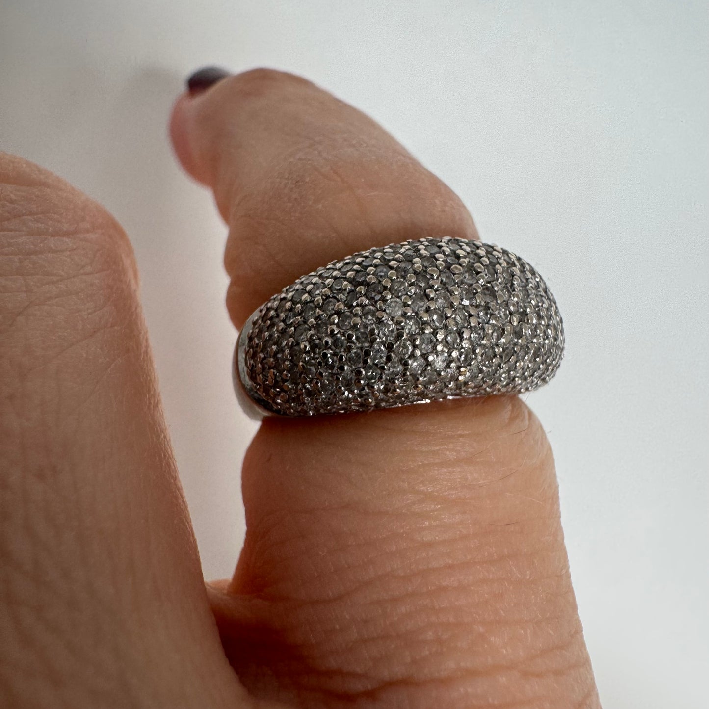 טבעת זהב לבן 14 קראט בעיצוב כיפה רחבה, משובצת יהלומים זעירים בשיבוץ פאבה צפוף.