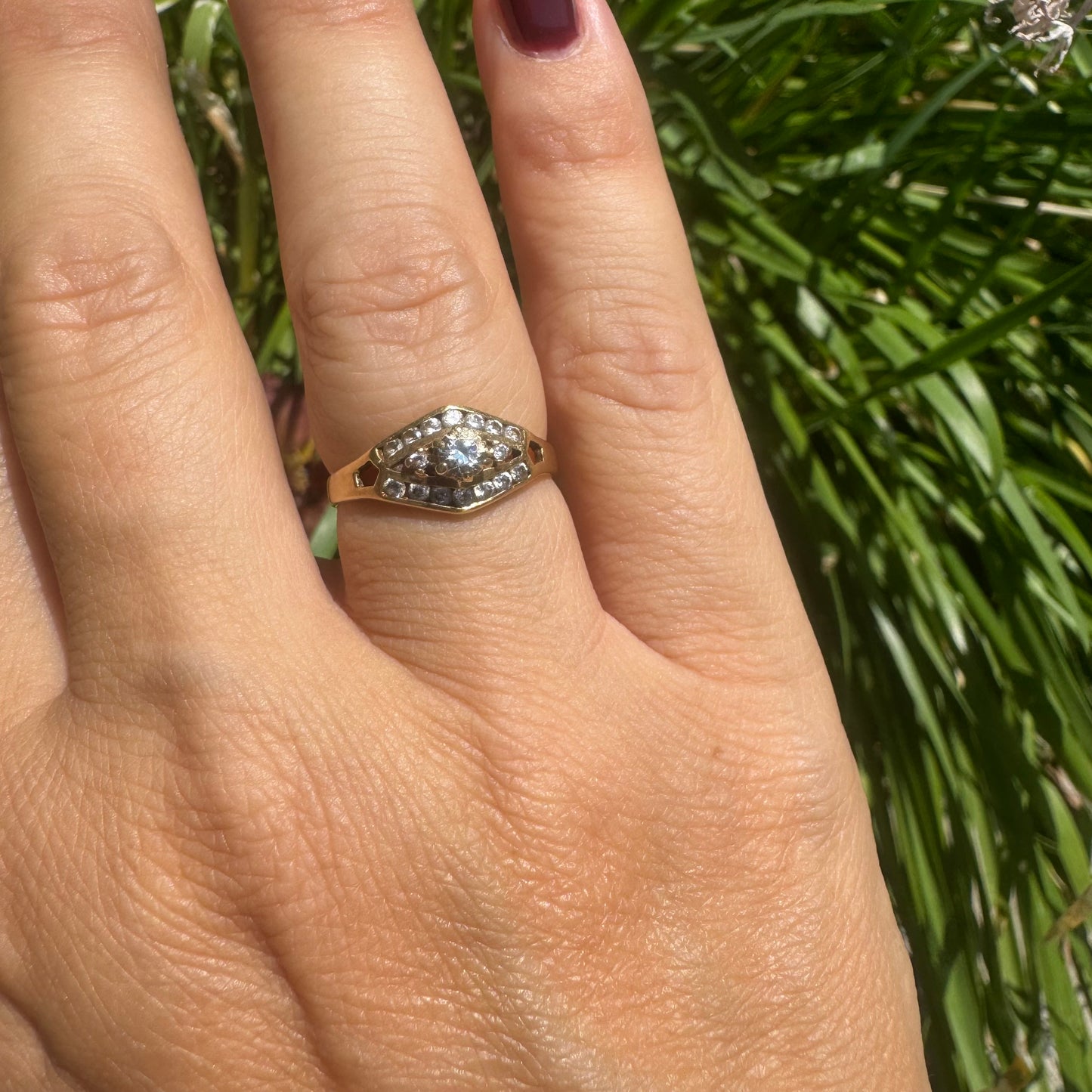 18K gold ring set with a central round Diamond, surrounded by rows of Diamonds in a decorative setting.
