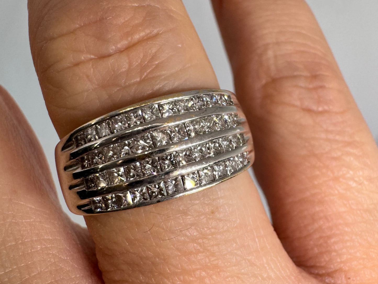 14K gold ring set with four parallel rows of princess-cut Diamonds.