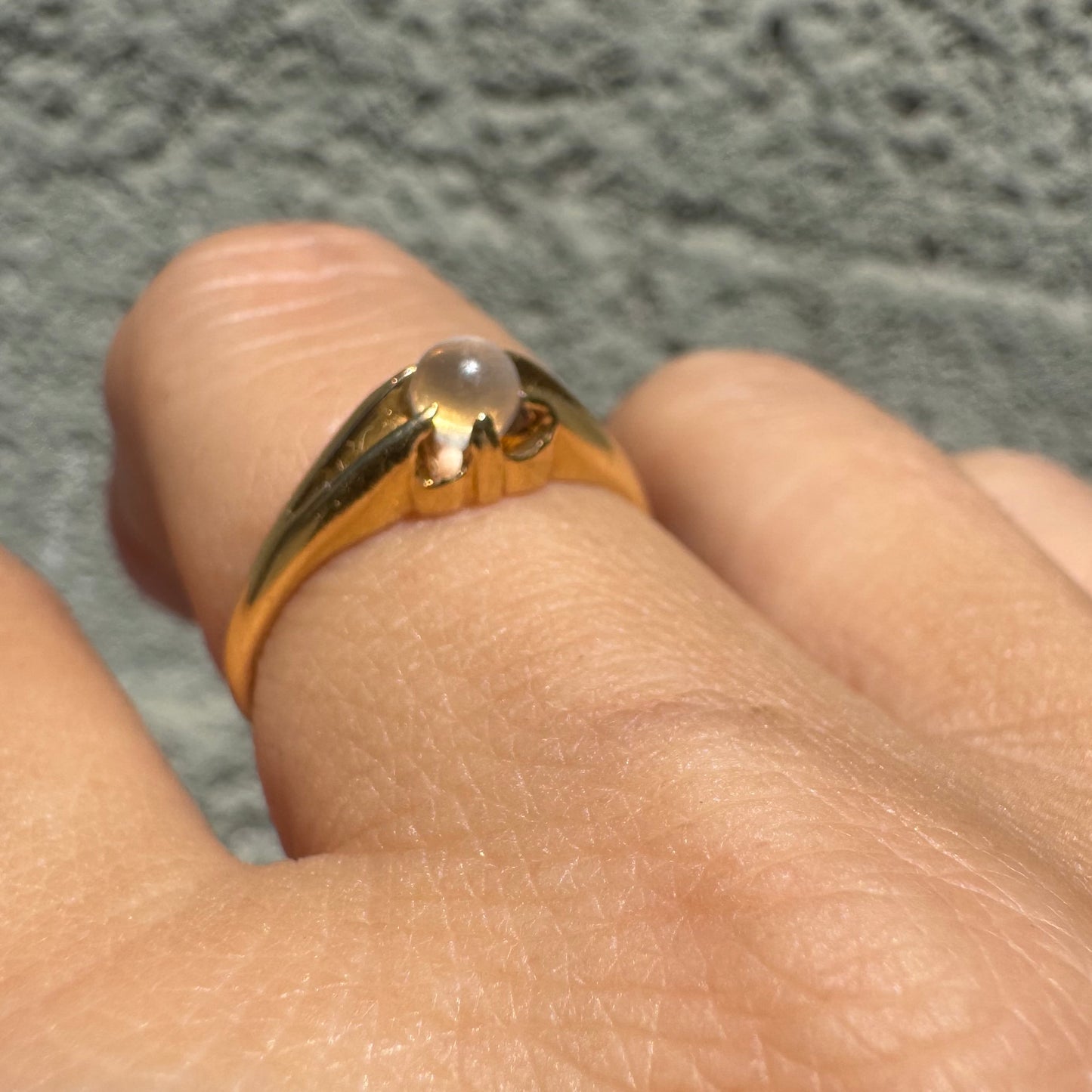 18K yellow gold ring featuring a smooth round Moonstone set in a delicate floral-inspired design.