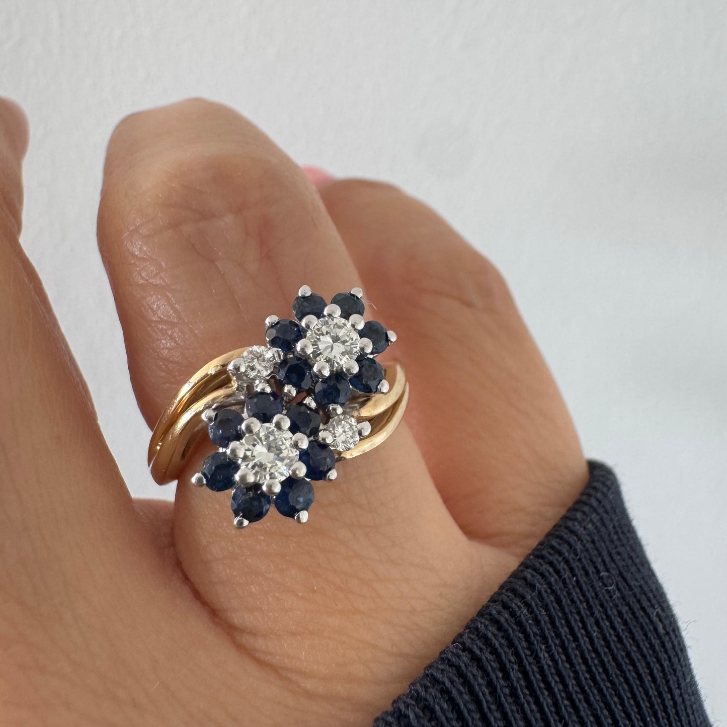 טבעת זהב צהוב 14 קראט משובצת אבני ספיר ויהלומים בעיצוב פרחים כפול.