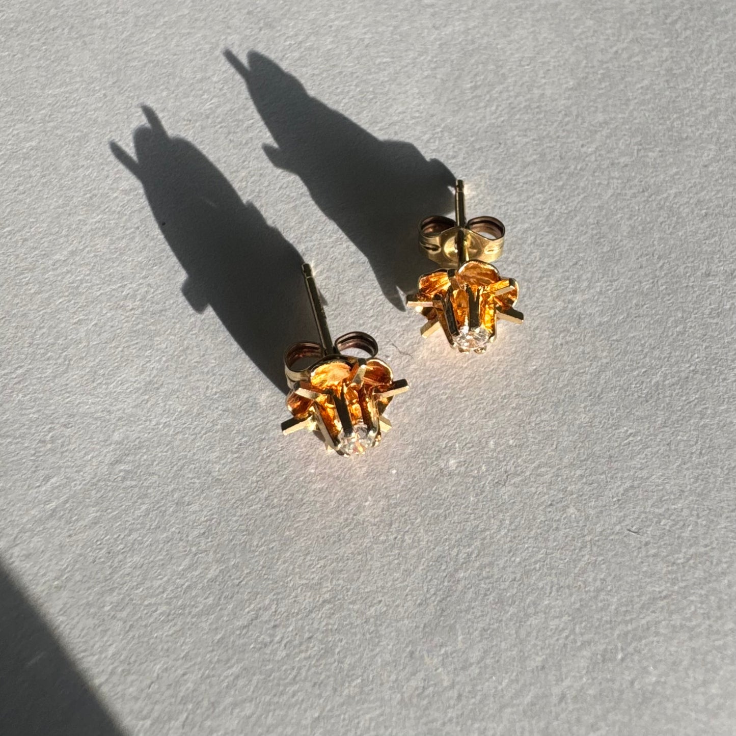 עגיל צמוד זהב צהוב 14 קראט בעיצוב פרח עדין, עם יהלום לבן במרכזו.