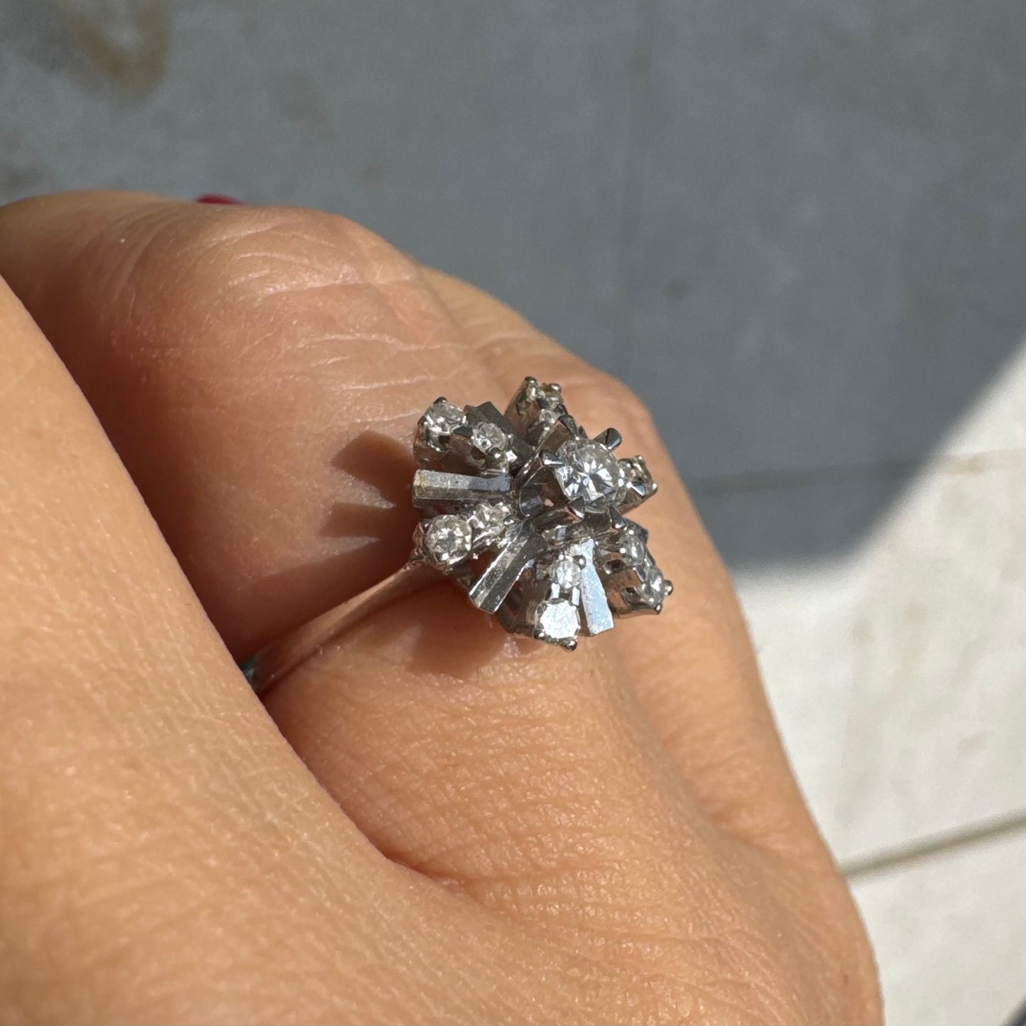 טבעת זהב לבן 18 קראט בעיצוב קרני שמש מרהיב, משובצת יהלומים הלוכדים את האור מכל כיוון. 