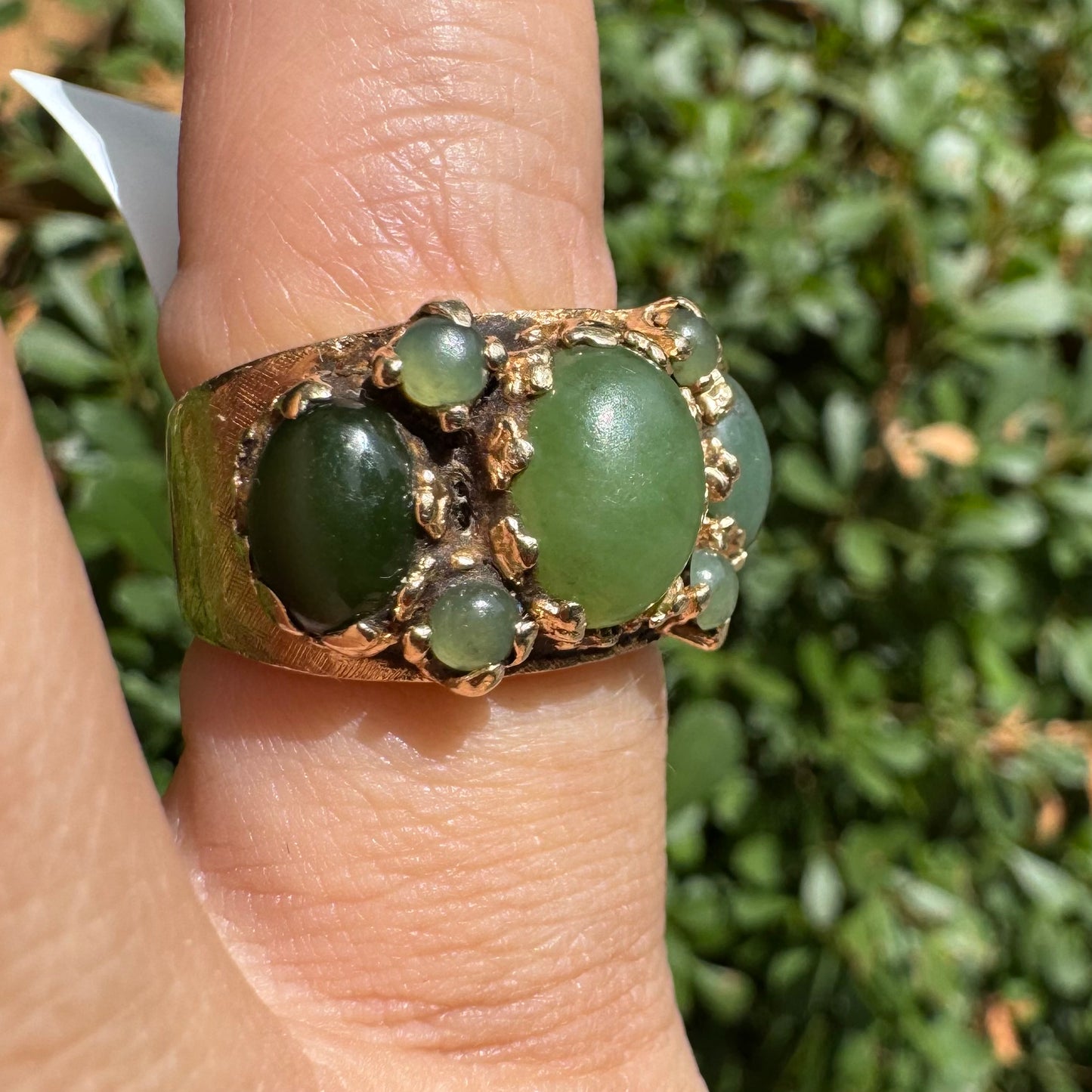 14K gold ring set with a central oval green Jade cabochon, framed by additional Jade stones in varying shades and sizes