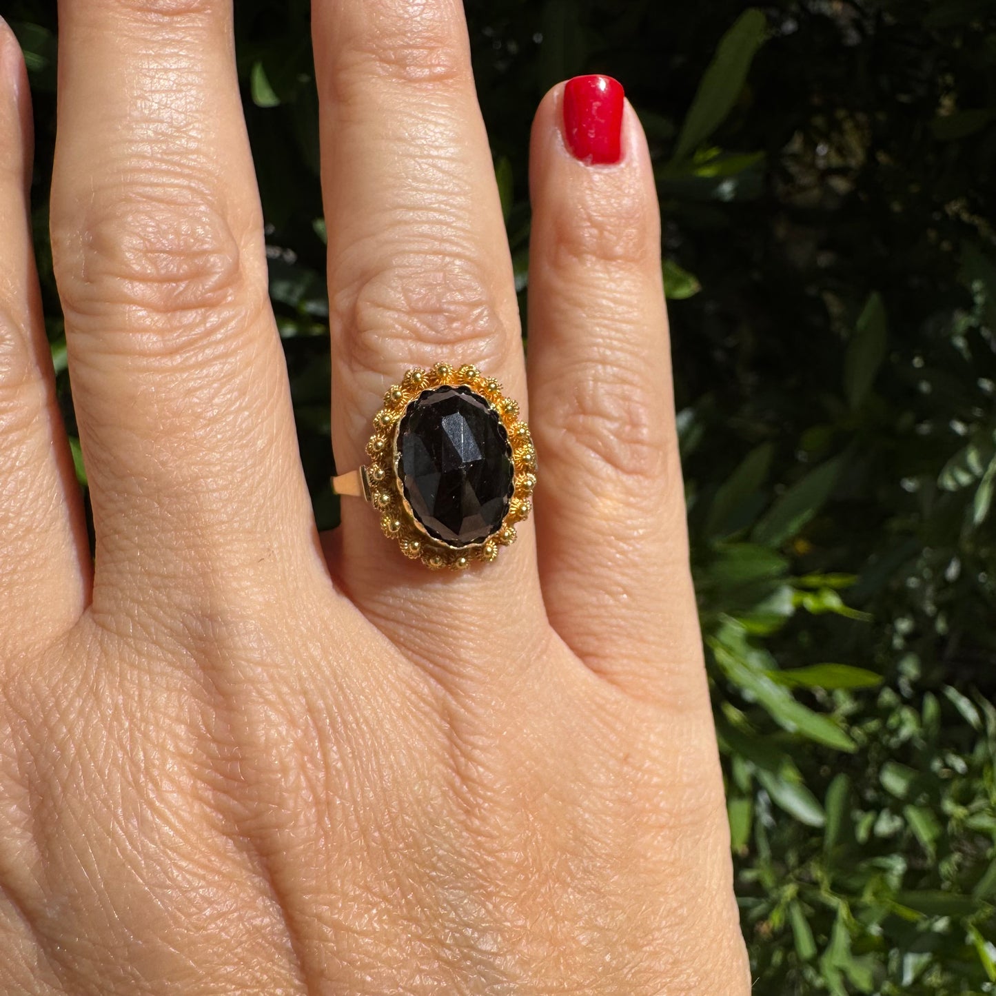 14K gold ring set with a large Garnet surrounded by delicate gold details