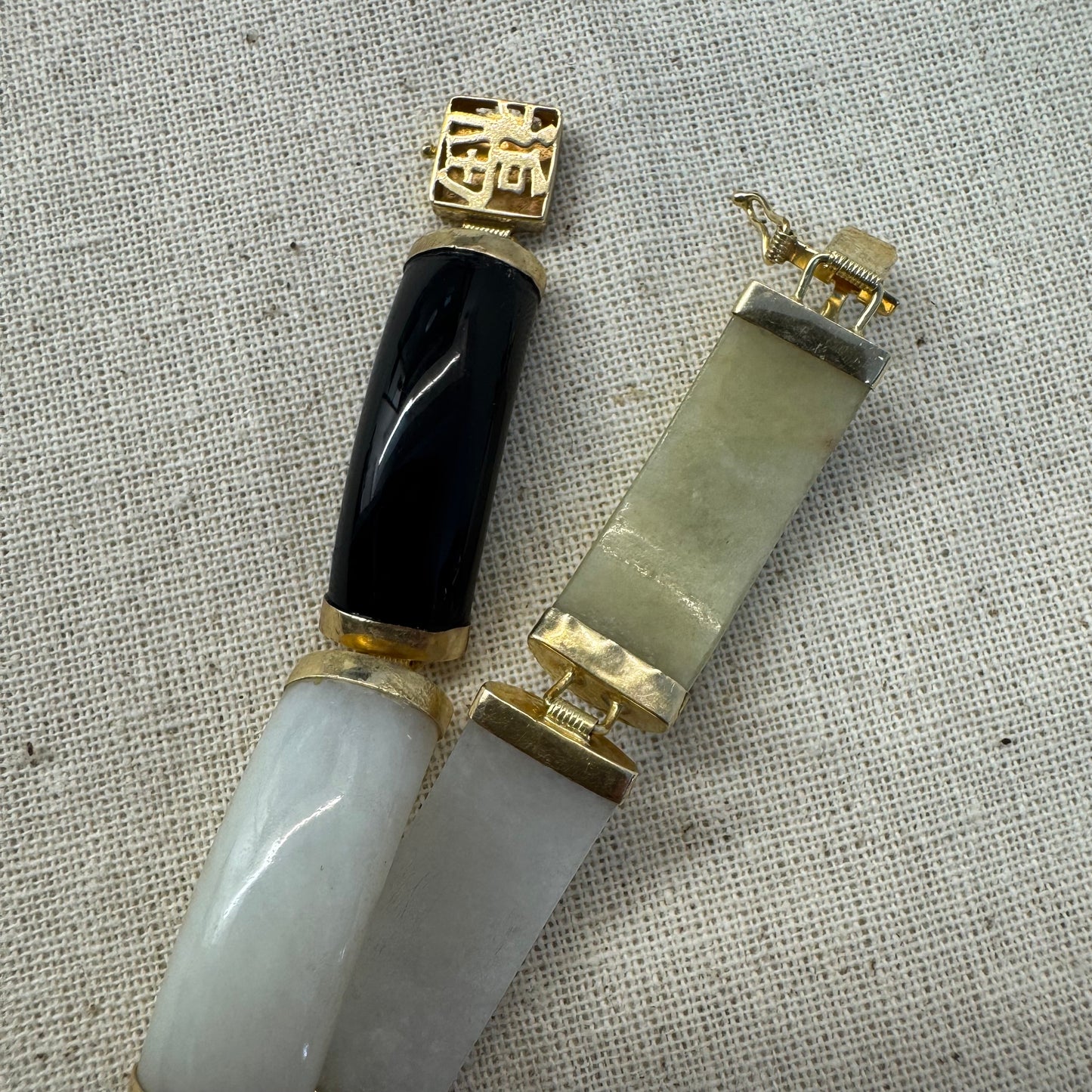 צמיד זהב צהוב 14 קראט עשוי מקטעי ג’ייד (jade) בשלושה גוונים – ירקרק, לבן ואדום – בשיבוץ זהב.