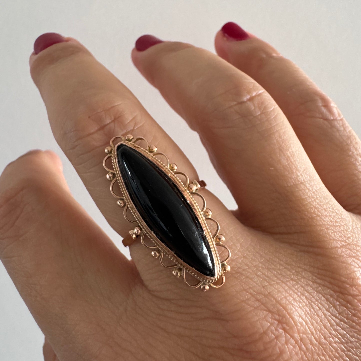 טבעת זהב אדום 14 קראט משובצת אבן אוניקס שחורה בחיתוך מרקיזה עם מבנה מאורך