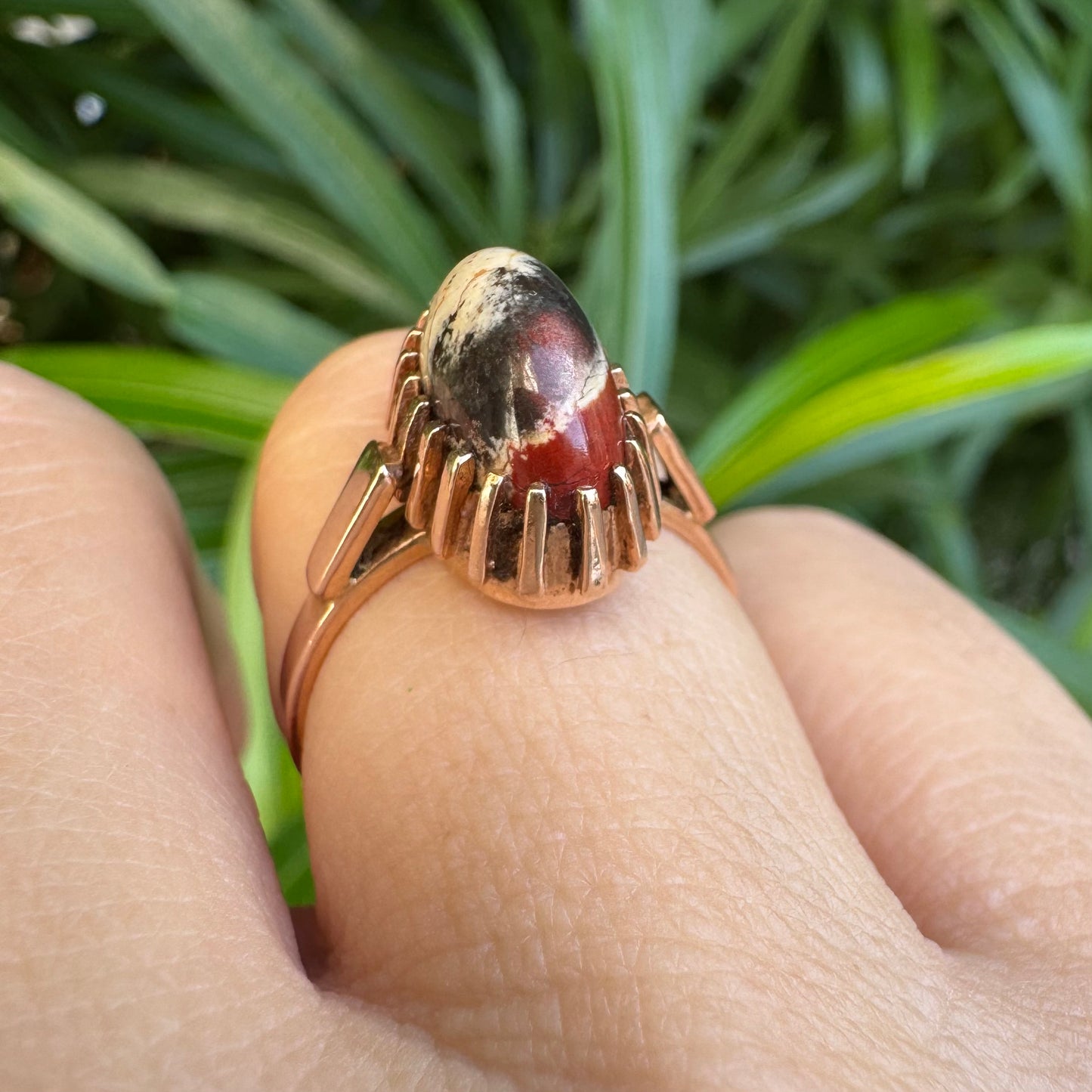 טבעת זהב 14 קראט משובצת אבן ג’ספר ייחודית בגווני קרם, שחור ואדום. 