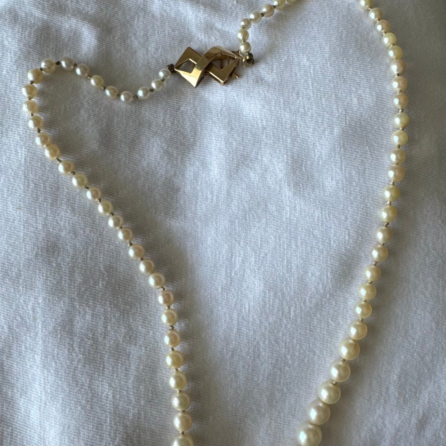 שרשרת פנינים קלאסית עם סוגר גאומטרי מזהב צהוב 14 קראט.