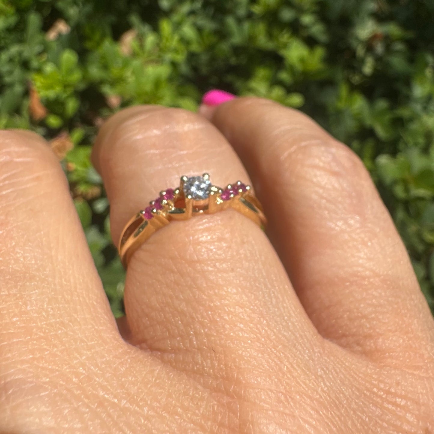 14K gold ring set with a central round Diamond, accented with Rubies along the band.