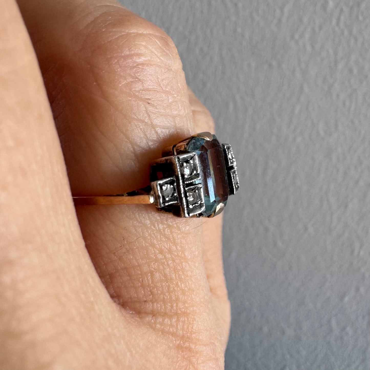 טבעת עתיקה מזהב 14 קראט, משובצת אבן אקוומרין מרכזית בחיתוך מלבני ויהלומים.