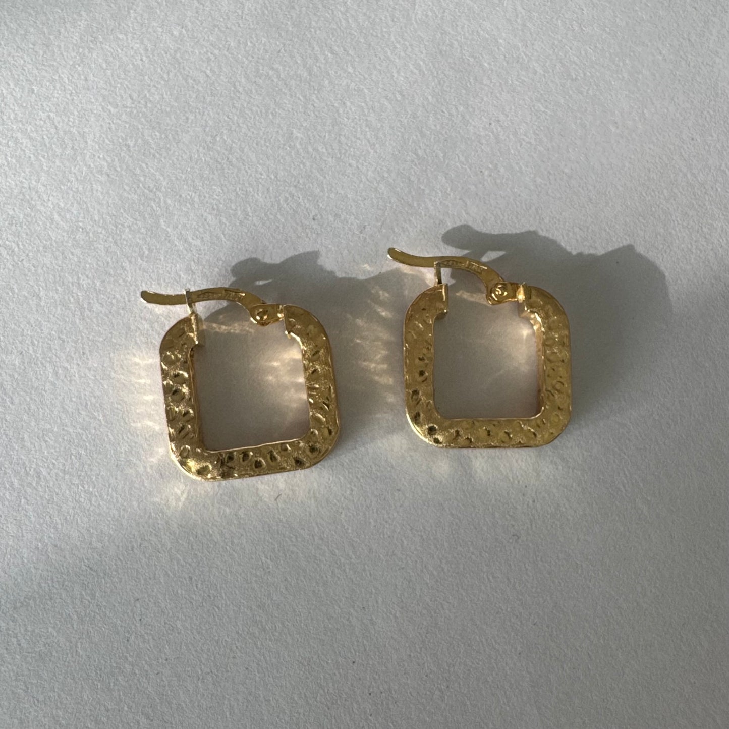 עגילי חישוק מרובעים מזהב 14 קראט בגימור מחוספס ומטאלי. 