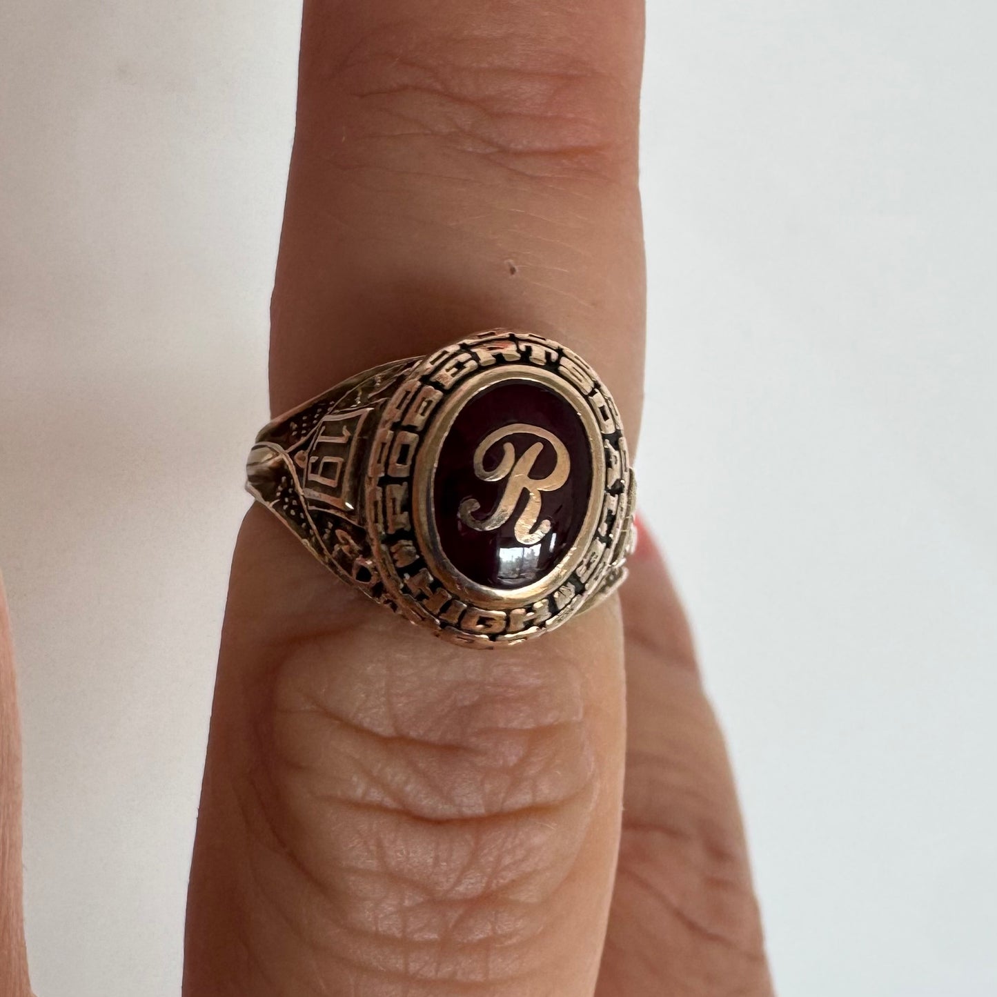 טבעת מחזור (Class Ring) מזהב 10 קראט, בעלת עיצוב אמריקאי קלאסי ובמרכזה אבן אדומה עם האות R עם חריטות וסמלים המעניקים לה אופי ייחודי ונוסטלגי.