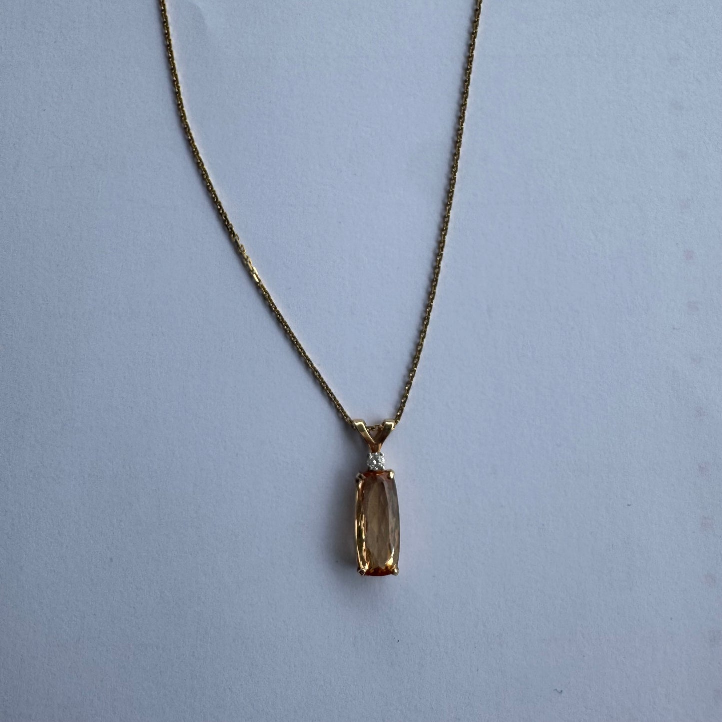 שרשרת זהב 14 קראט עם תליון זהב 14 קראט משובץ אבן קוורץ מלבנית בגוון שמפניה חמים, ומעליה יהלום נוצץ להדגשה עדינה של הברק.