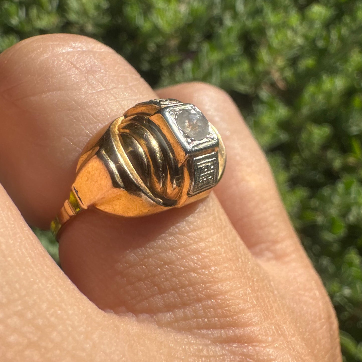 18K gold ring featuring a central round Diamond set in a square bezel with decorative details.